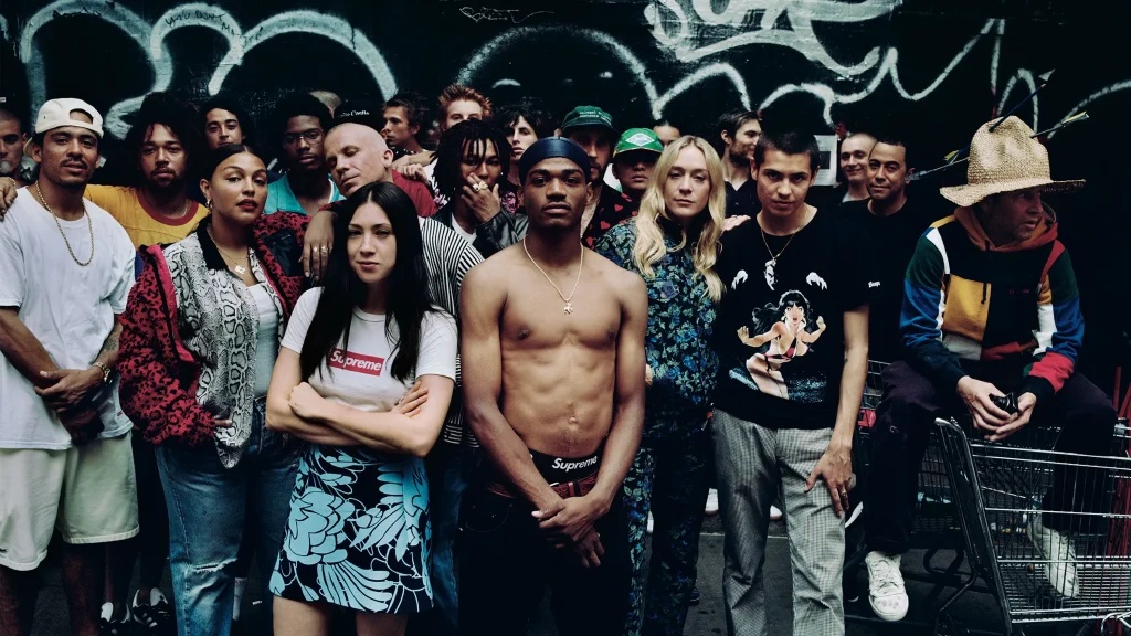 Jovem urbano vestindo Supreme streetwear com logo vermelho visível, representando estilo de moda urbana autêntico